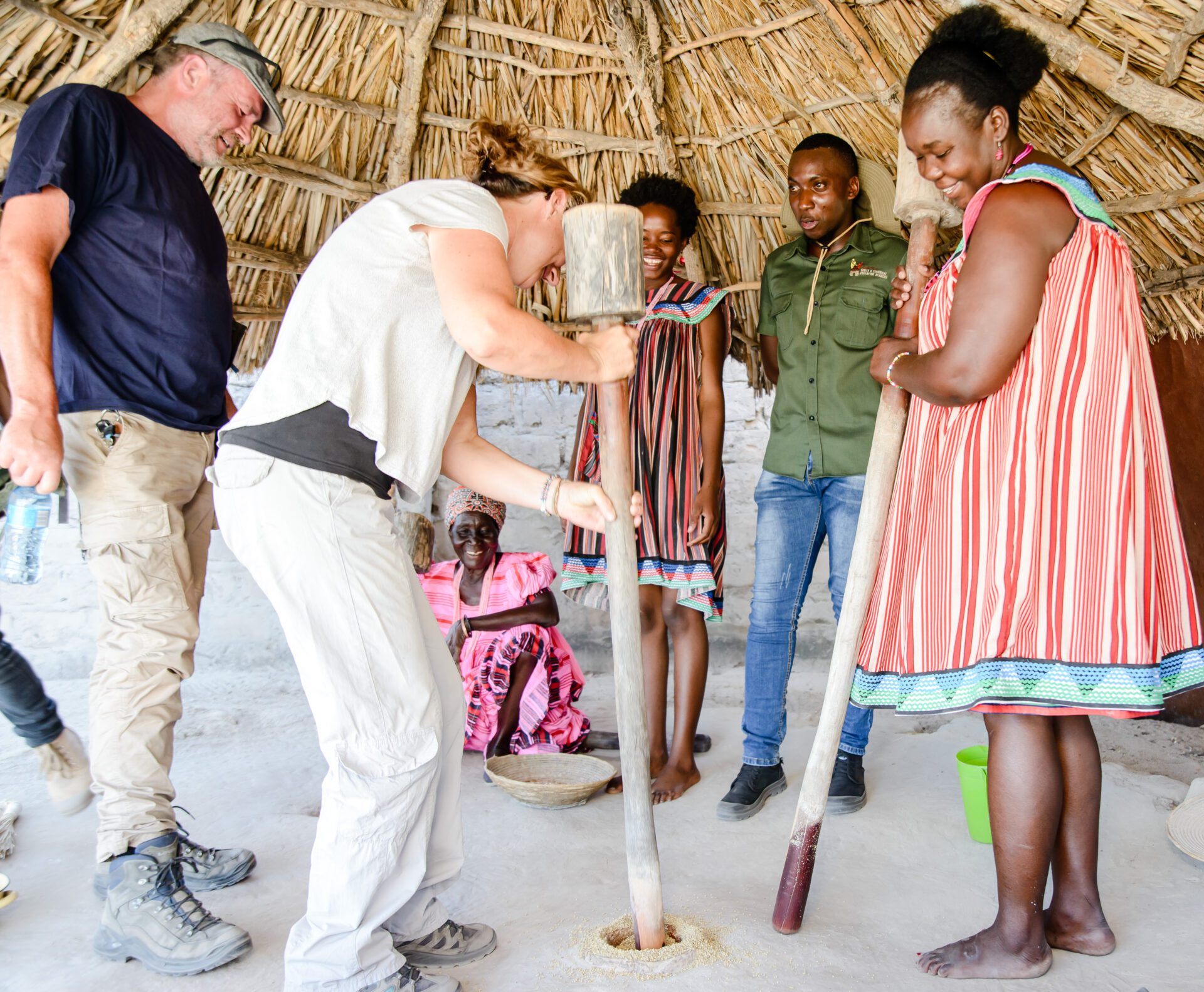 Image 22 a group of people standing around a hut